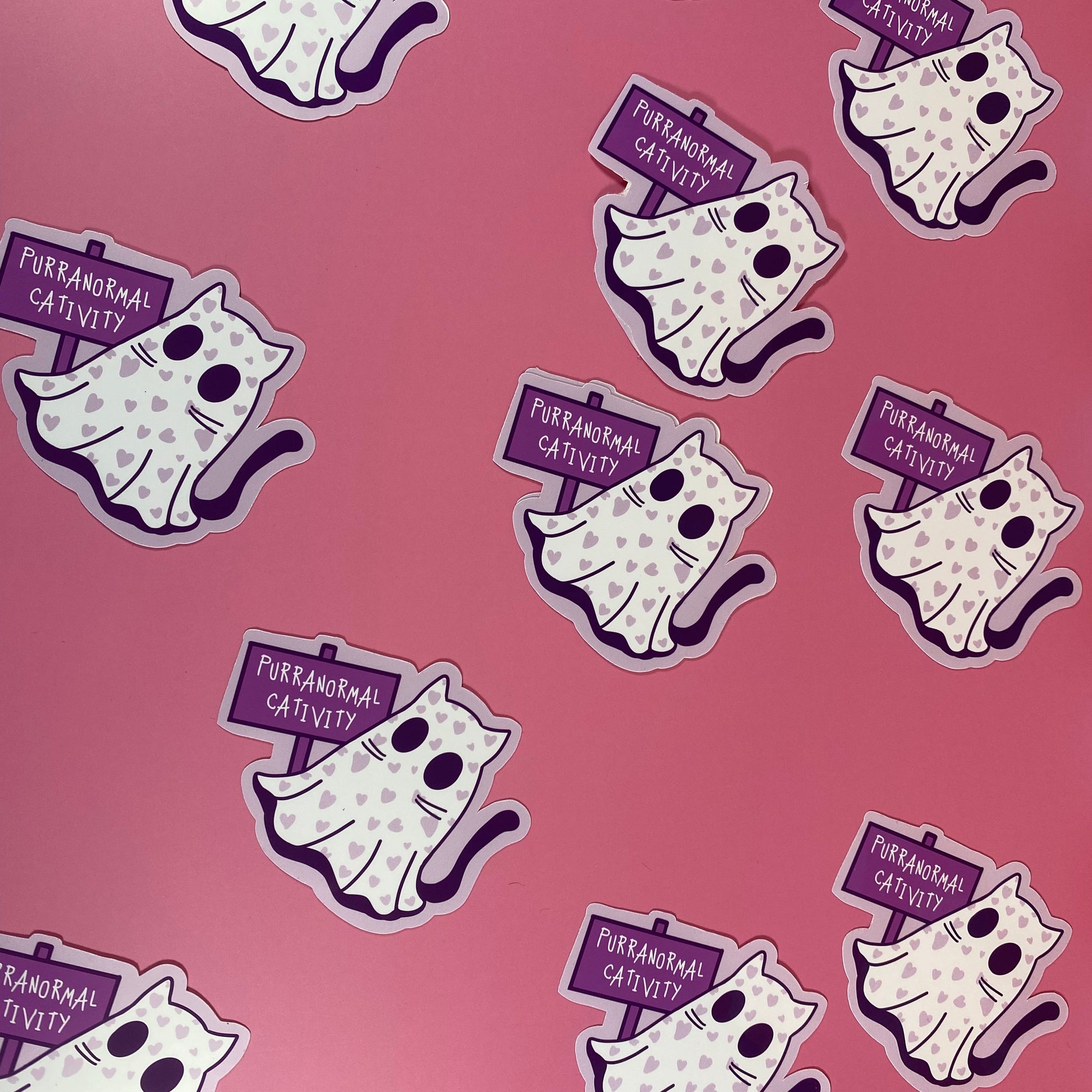 Pattern of cartoon cats with 'Paranormal Activity' signs on a pink background