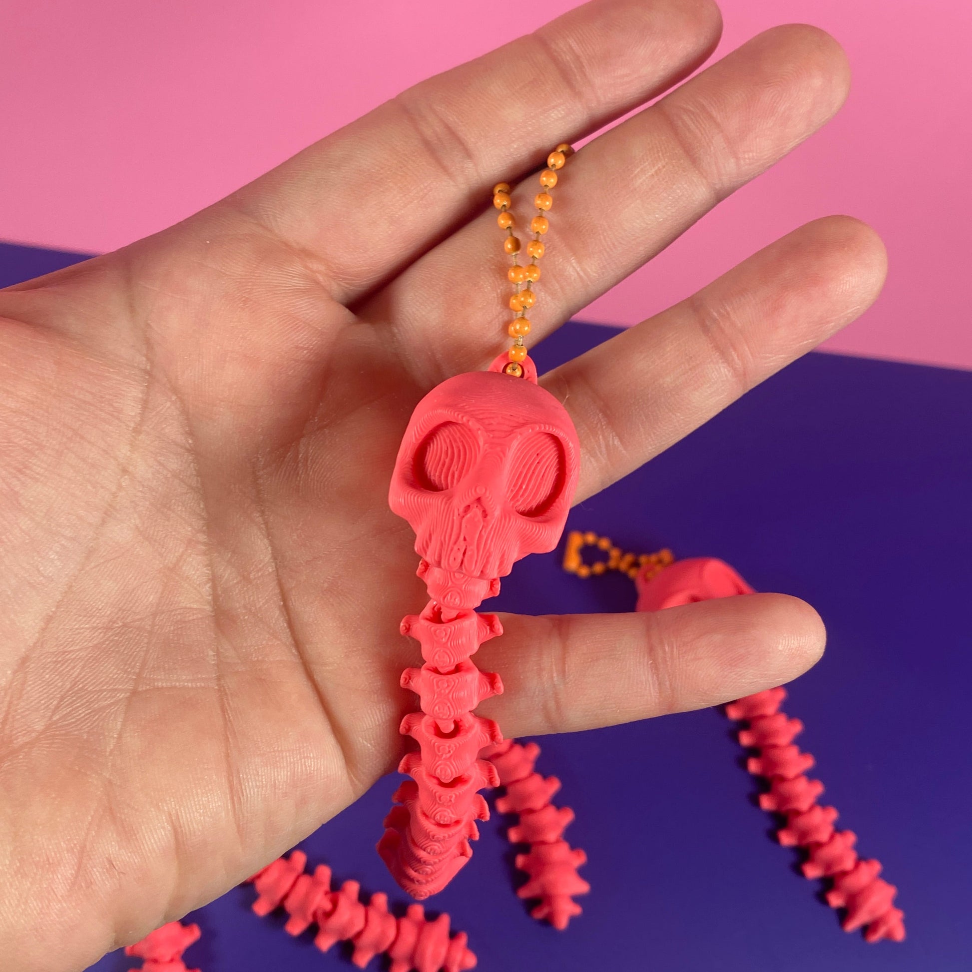 Pink textured object on a hand with a pink and purple background