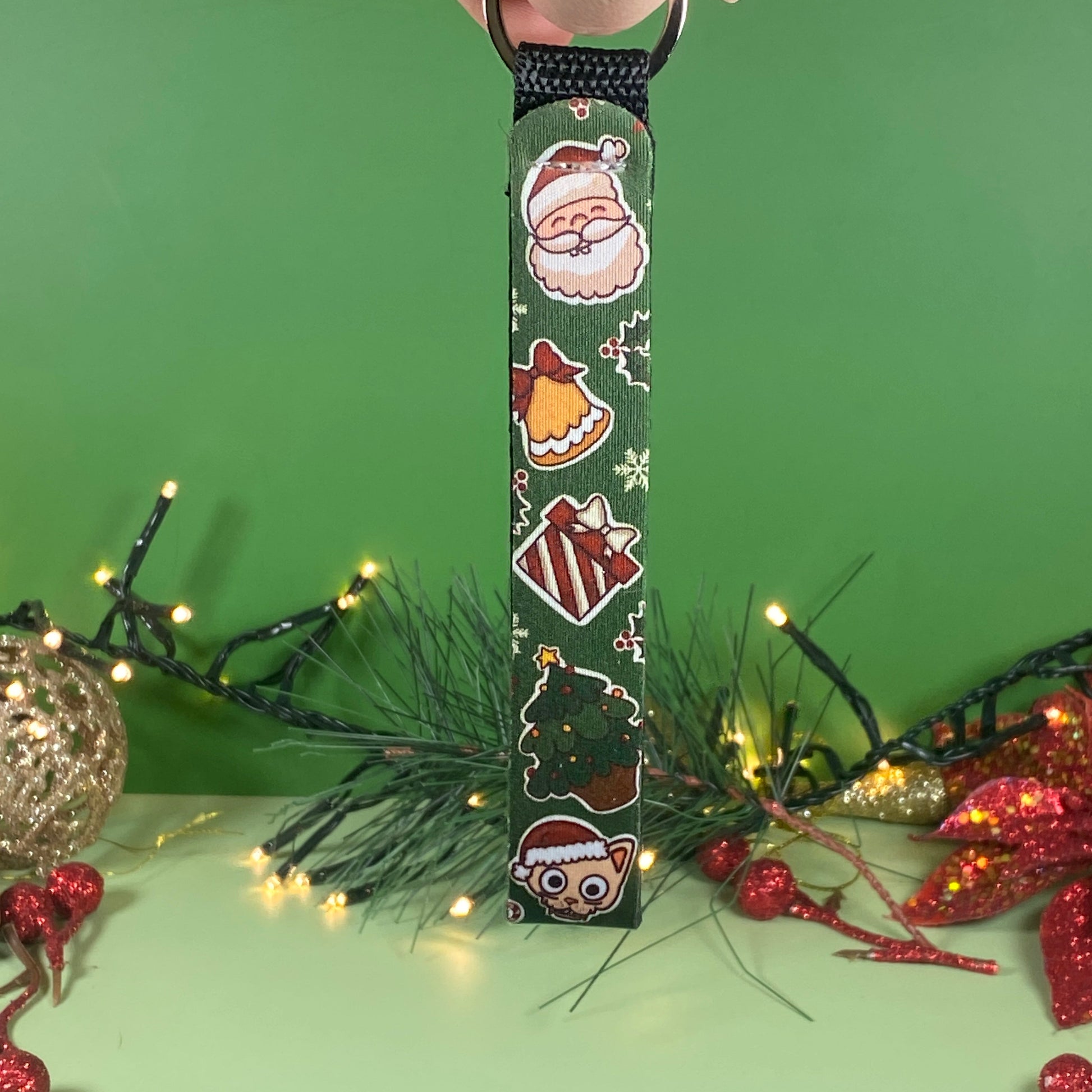 Decorative key chain with Christmas-themed designs on a green background